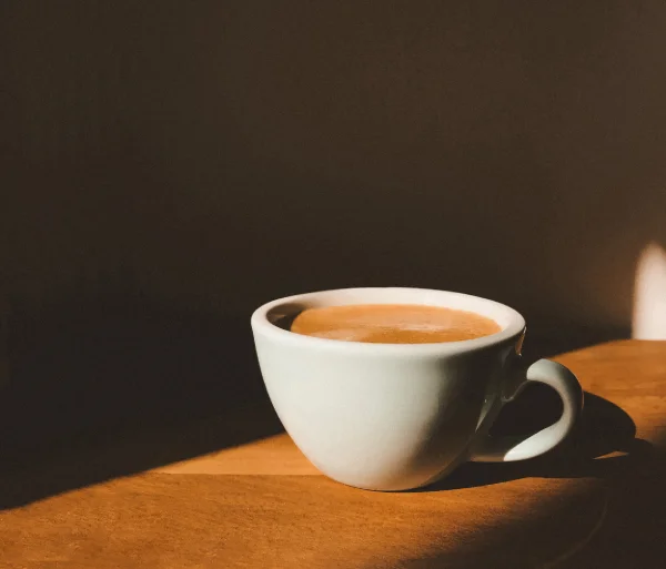 Lungo-koffie in witte kop op donkere achtergrond.